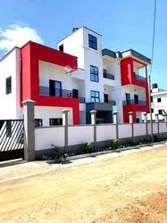 Immeuble moderne rouge et blanc avec balcons et clôture de sécurité.