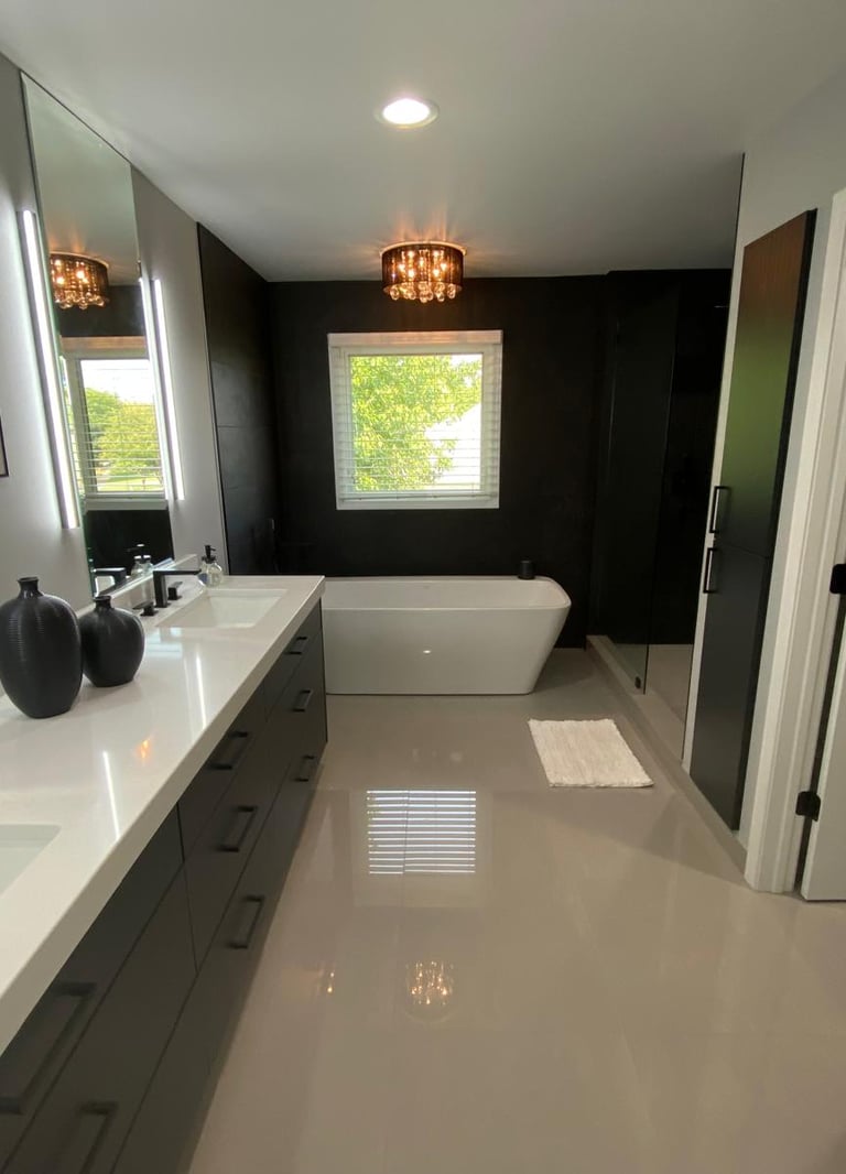 Modern luxury bathroom with double vanity, white quartz countertops, and a freestanding soaking tub.
