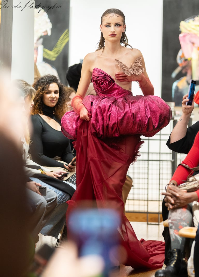 a woman in a red dress is walking down the runway