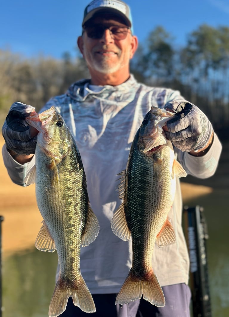 holding two largemouth fish
