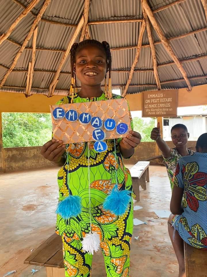 Petite fille qui tient une pancarte avec écrit Emmaüs AFA