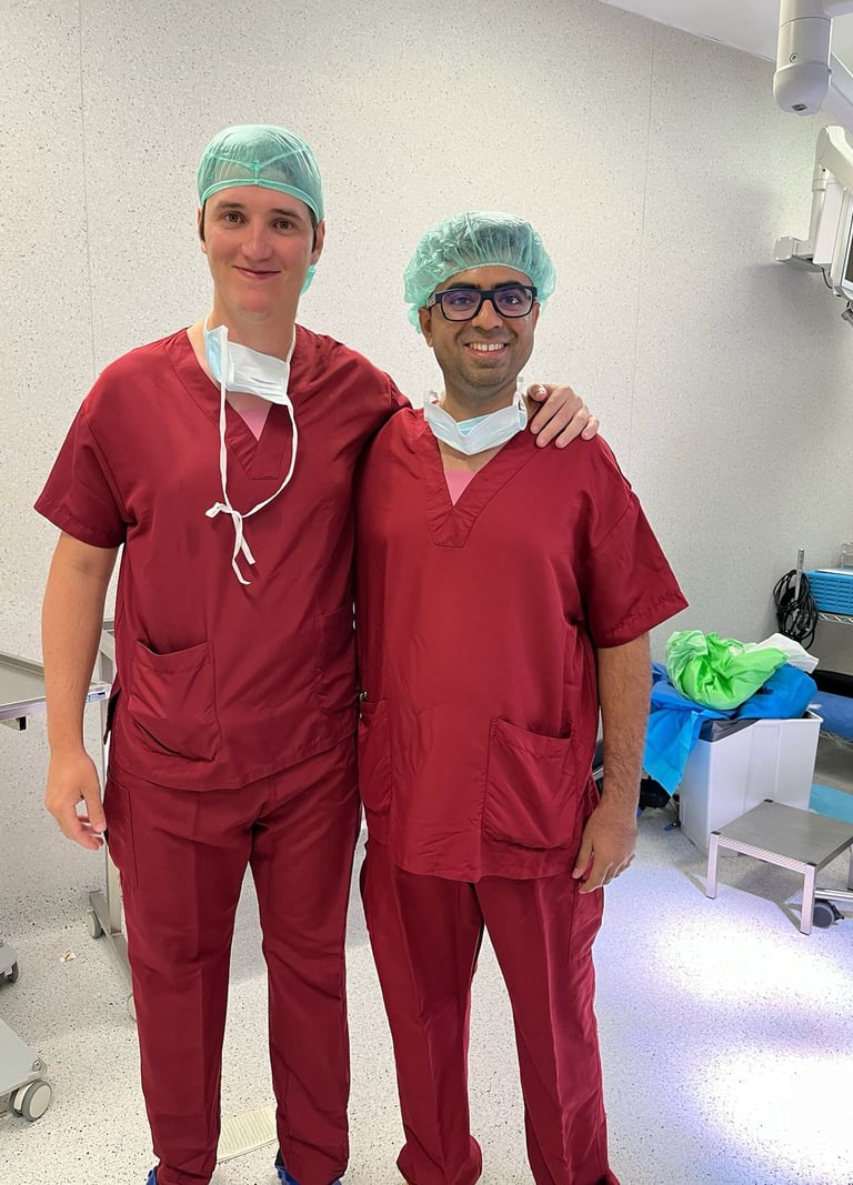 Two smiling male surgeons in red medical scrubs and hairnets dr piyush vasaikar dhule