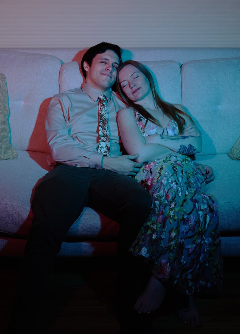 a man and woman sitting on a couch napping