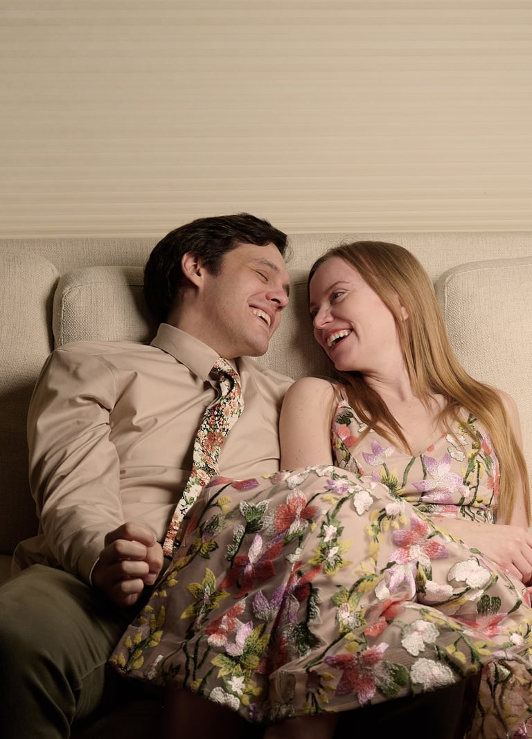 a man and woman sitting on a couch smiling at each other