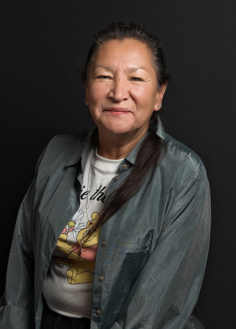 a female Native American with long hair and necklace smiling