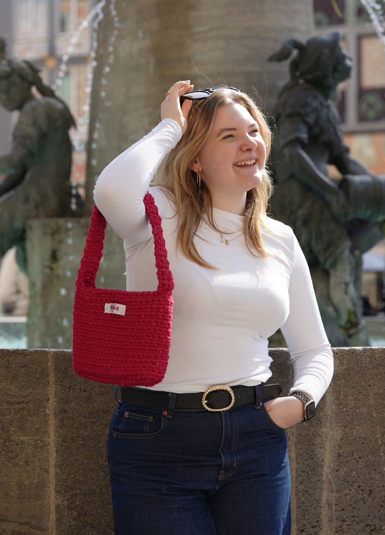 Leni von Frisie mit der handgehäkelten roten Marienplatz Magic Tasche – handgemacht in München, foto