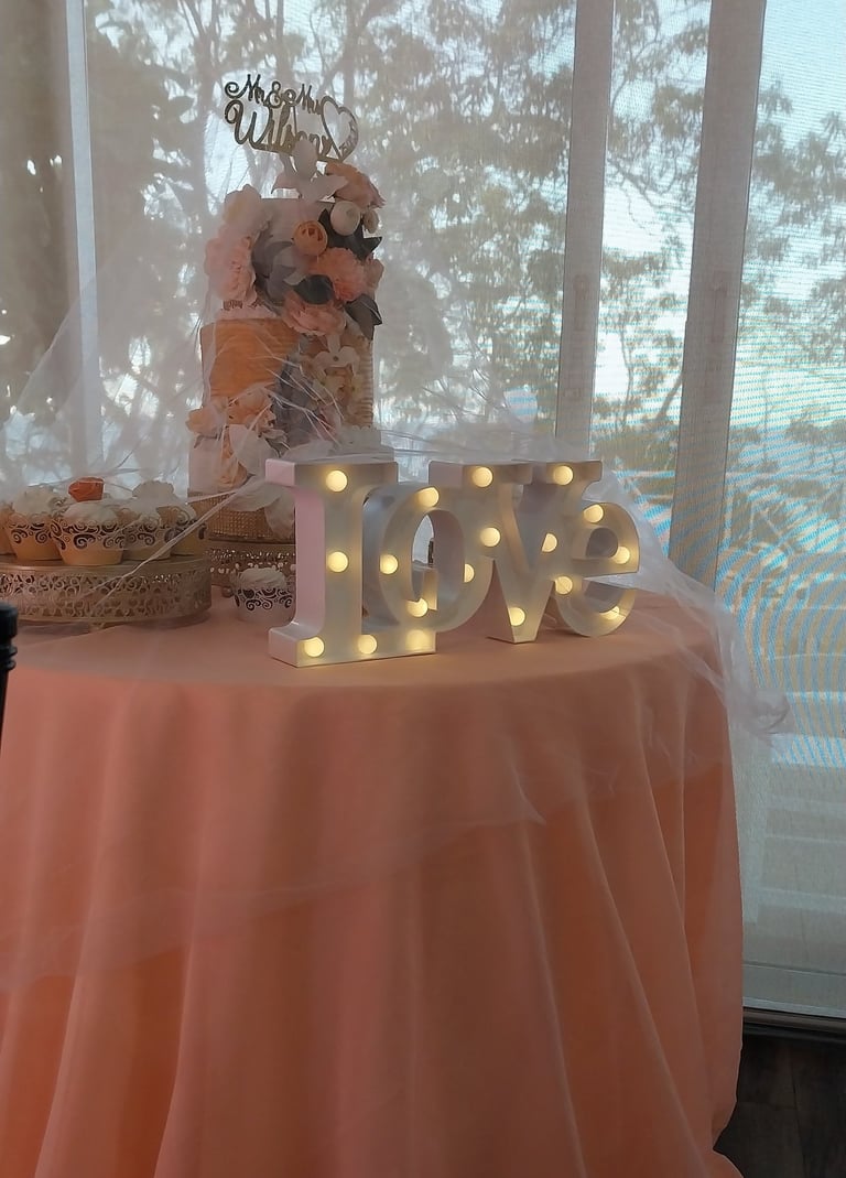 a table with a table cloth and a cake and a love sign