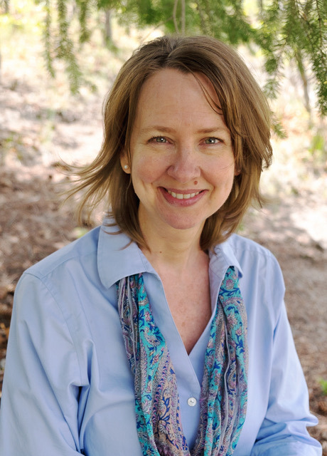 a woman in a blue shirt and scarf around her neck