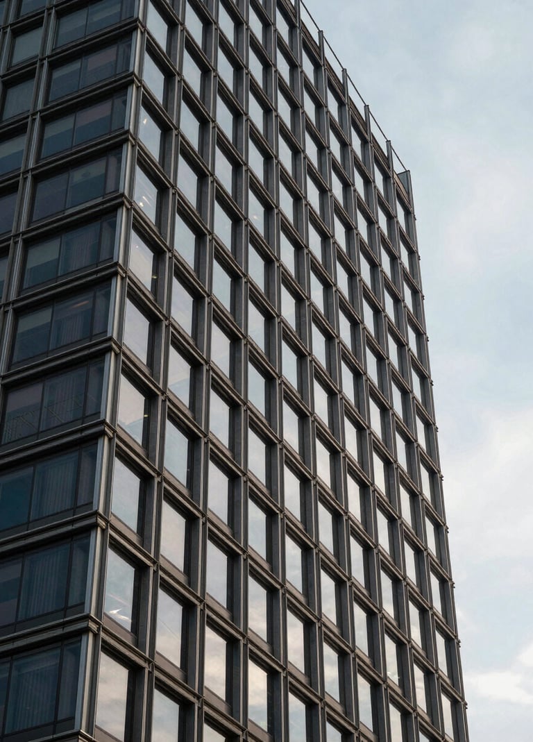 Architectural detail of a modern corporate building in Brazil. Steel and glass construction reflecting a pale blue-grey sky. The image conveys a forward-thinking and sophisticated brand identity.