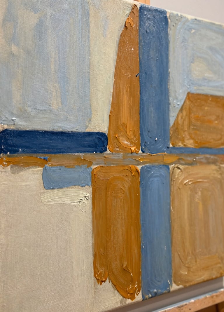 A close-up photograph of an experimental oil painting on a textured linen canvas. The artwork features bold, expressive strokes of slate blue and warm ochre over a soft alabaster base, reflecting a Northern European / Welsh / British modern art aesthetic. Shallow depth of field, natural gallery lighting.