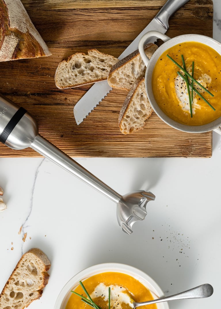 Food product photography - a table with bread, soup and a blender