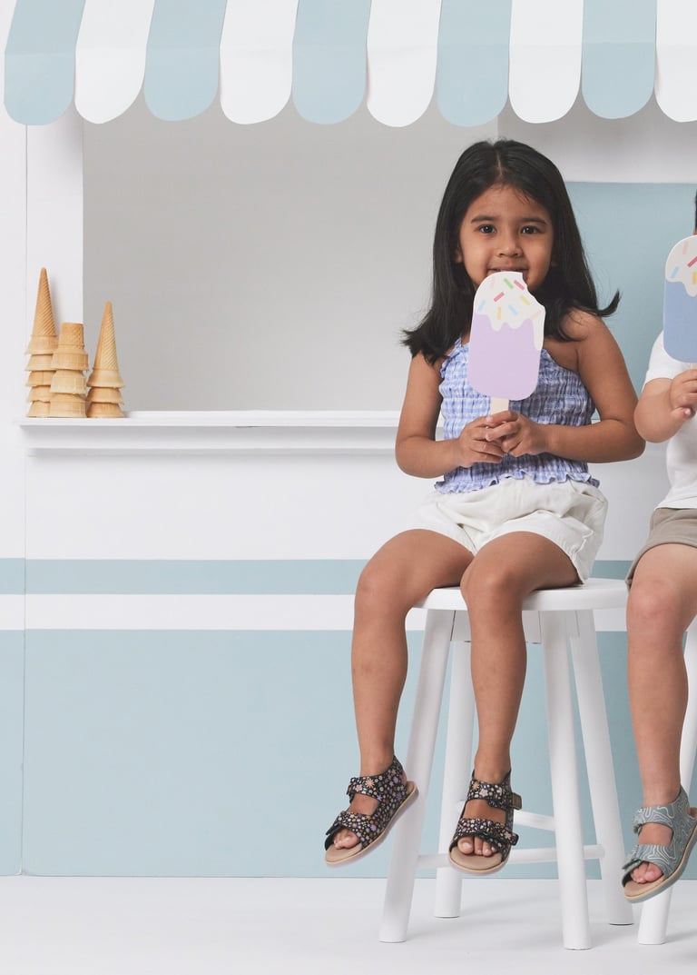 Fashion campaign photography - two children sitting on a stool in front of a ice cream cone