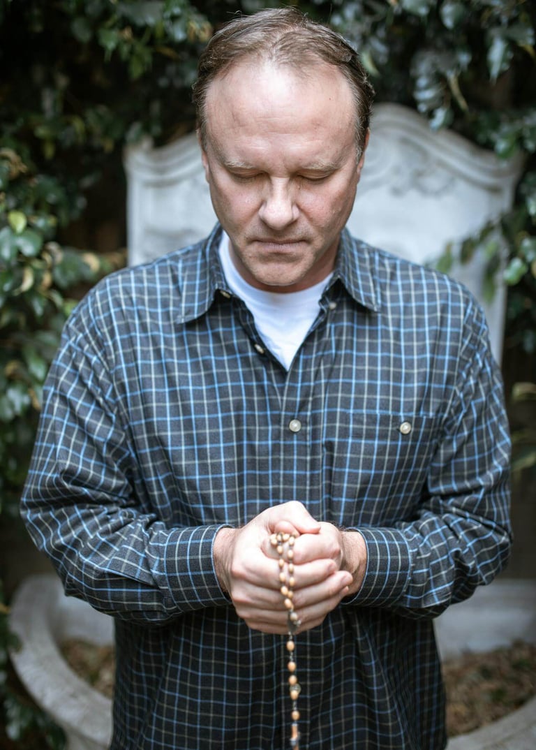 a man holding a rosary and a rosary