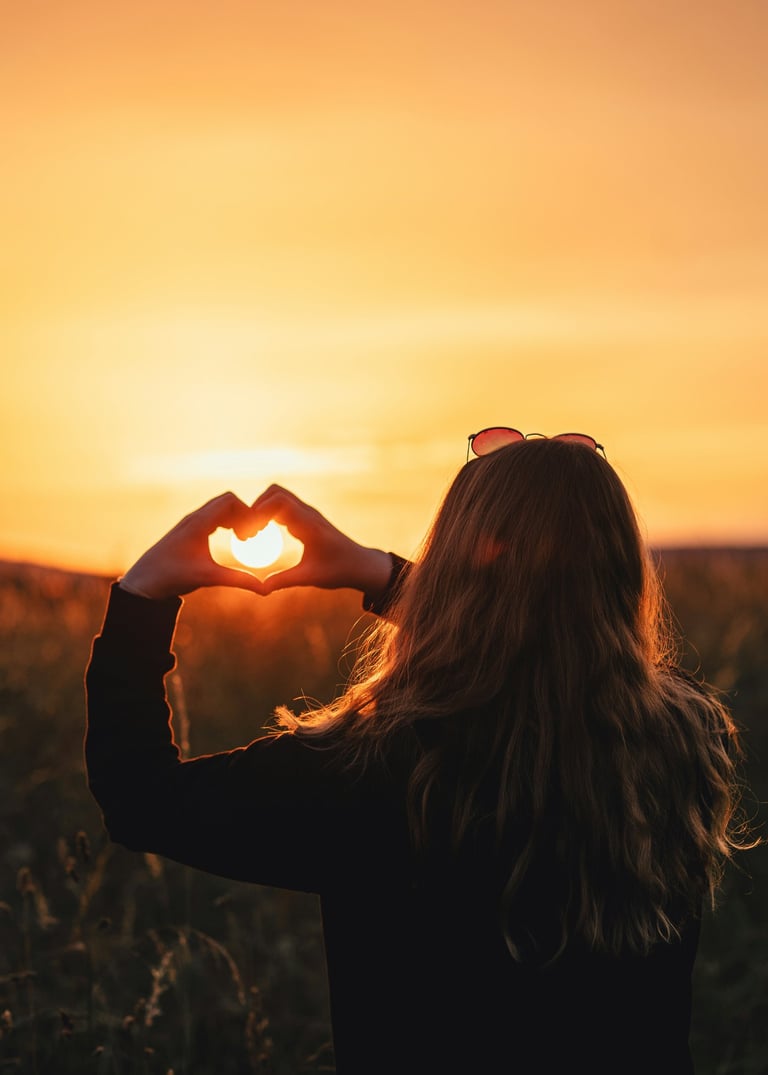 Femme formant un coeur avec ces mains devant un soleil pour etre accompagnée a plonger au coeur