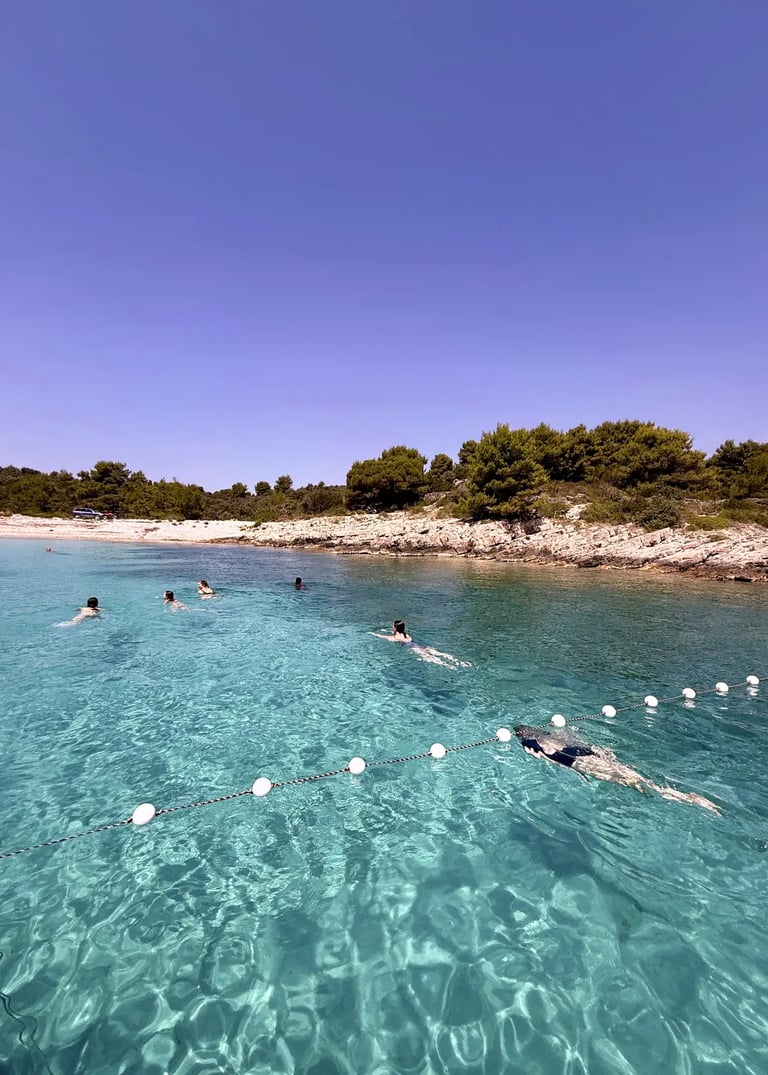 Girls swimming and diving in crystal-clear water at Solinska Bay Drvenik Veliki Croatia during a private boat trip from Split