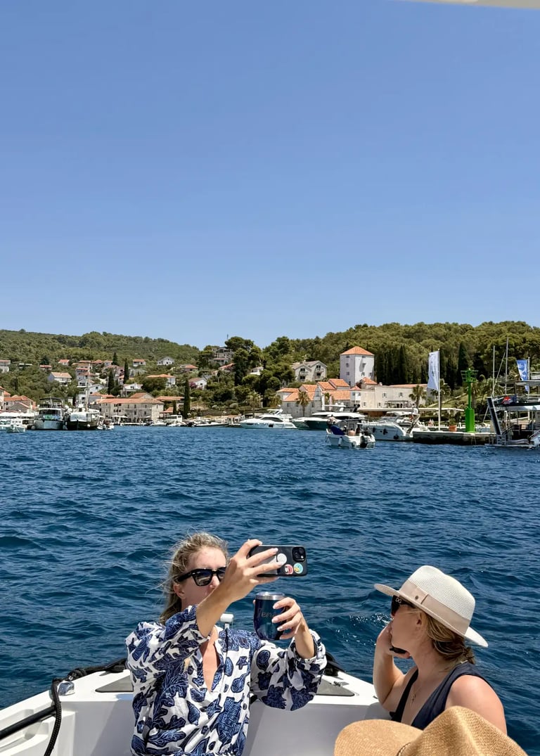 Woman taking a selfie at the coastline of Maslinica on Solta, Croatia from a boat on a private half-day tour from Split