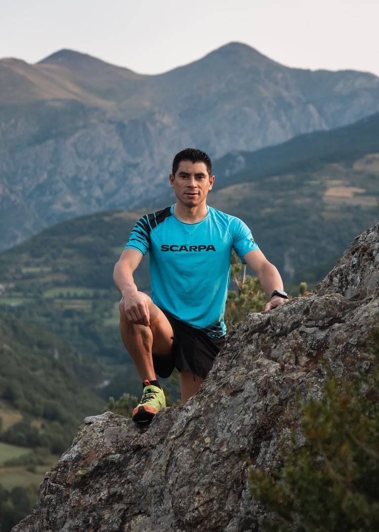 a man in a blue shirt is sitting on a rock