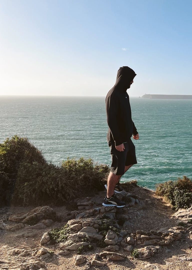 a man standing on a cliff overlooking the ocean