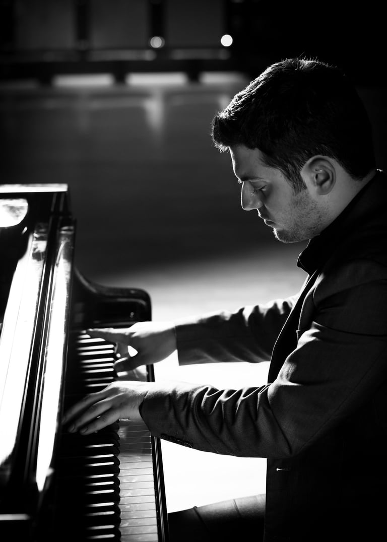 Stathis Chomatsas playing piano in a concert hall during a photoshoot