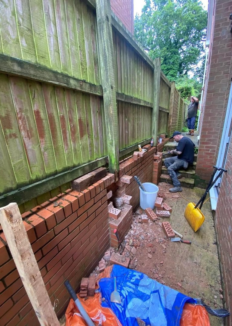 a man is fixing a damaged brick wall