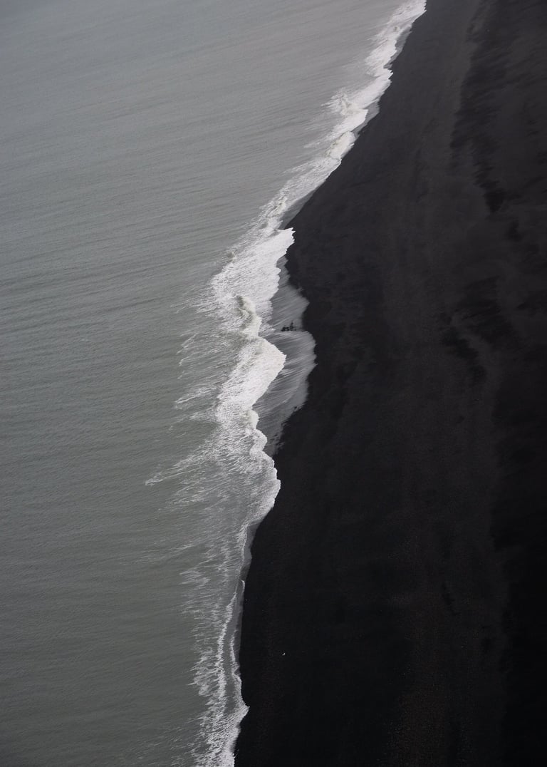 a person walking along a beach with a surfboard