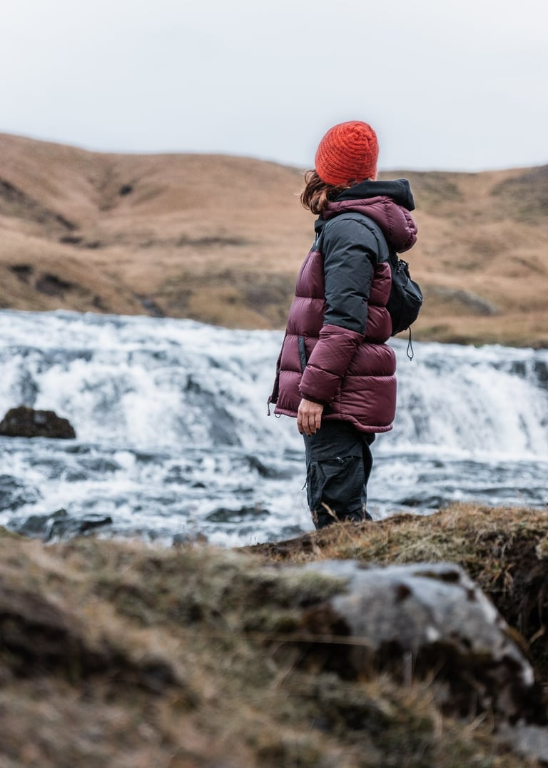 a person standing on a hill with a backpacker