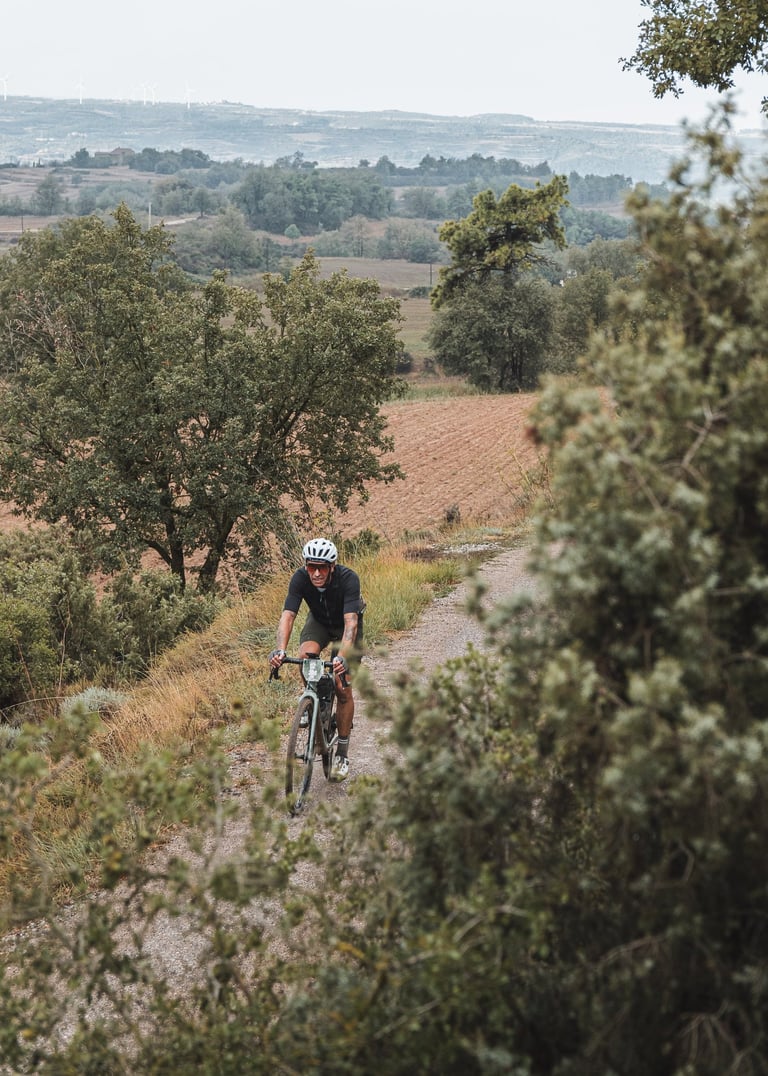a man riding a bike down a dirt road