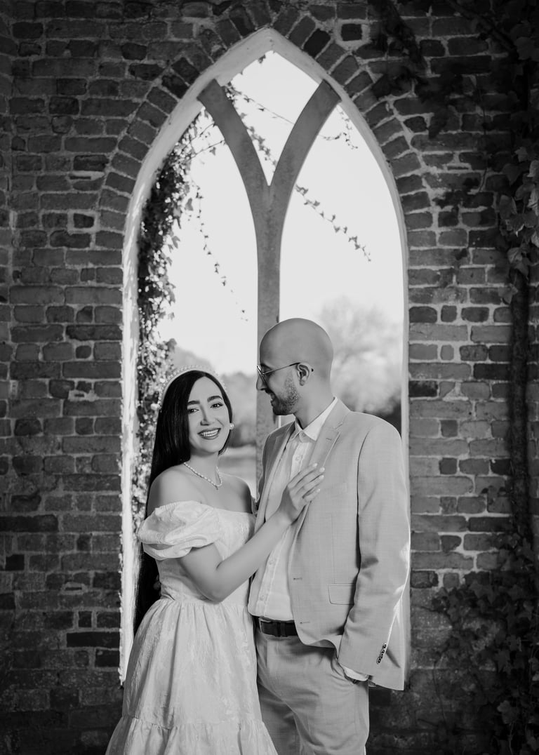 Couple standing in a brick archway during their Surrey engagement shoot by Fred Art Studio.