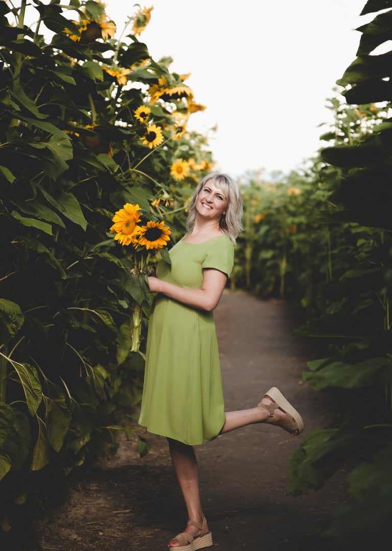 SEO founer of agency a woman in a green dress standing in a field of sunflowers