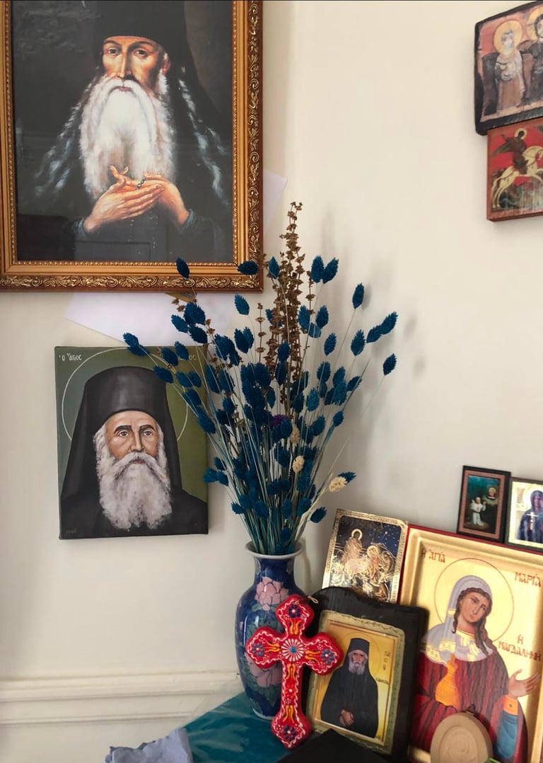 Coin prière de la maison de Berdiaev avec icônes orthodoxes, portrait de saint et vase de fleurs.