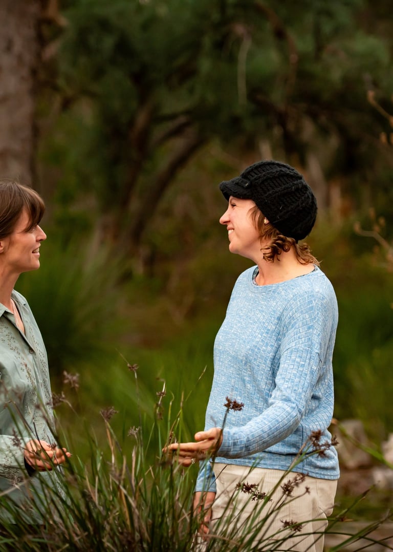 Joanna talking to a gardening client while looking at a native plant