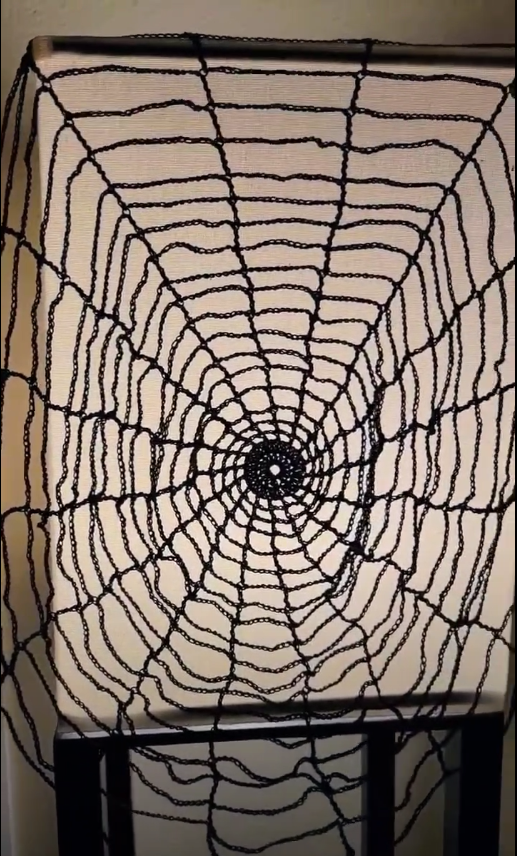 a black crochet spider web