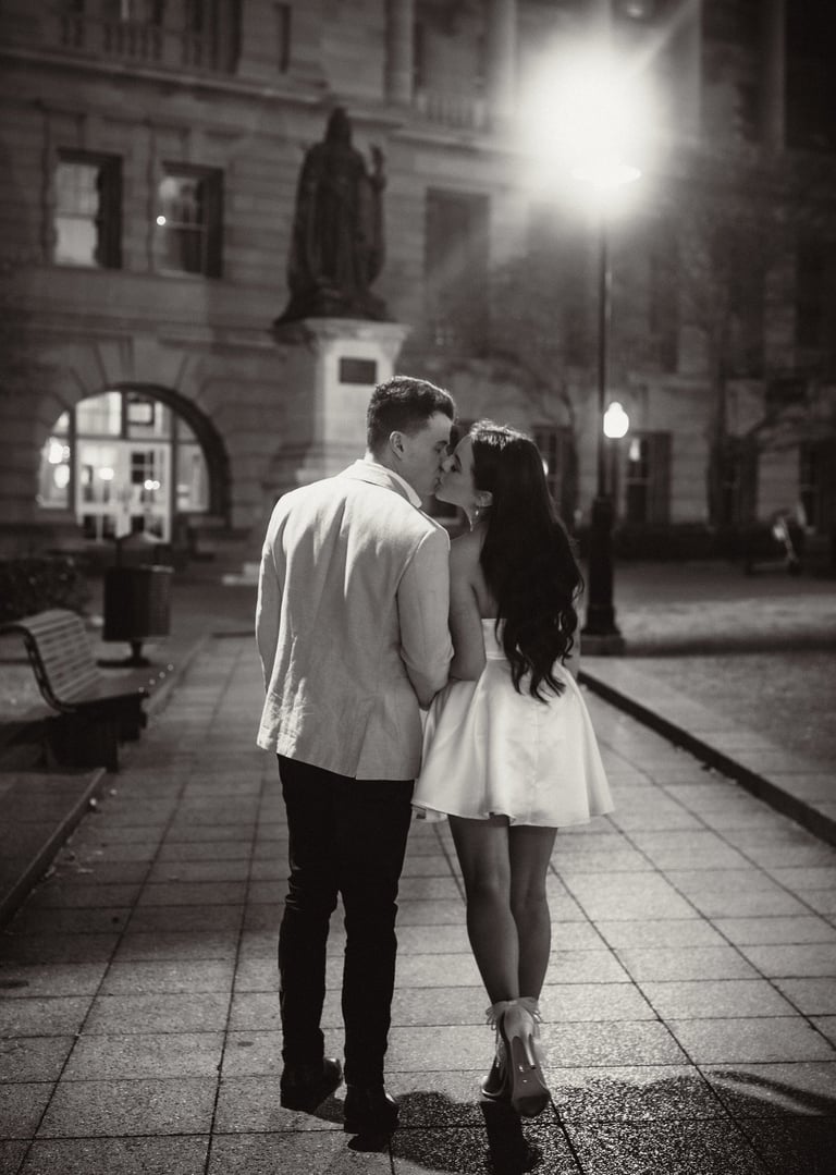 a couple kissing in a city street at night