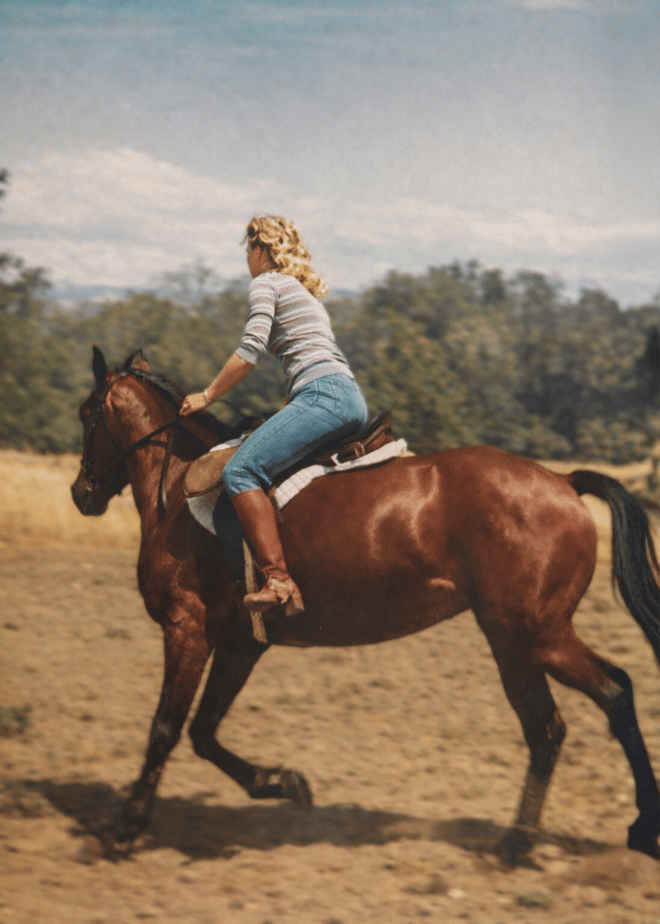 Nancy Jo riding one of her horses outdoors