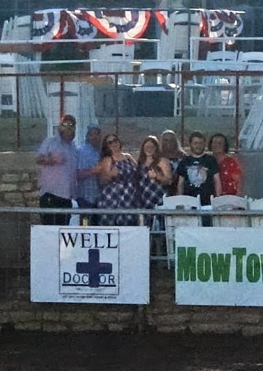 The Well Doctor crew behind our sign at the Wimberley VFW Fourth of July rodeo