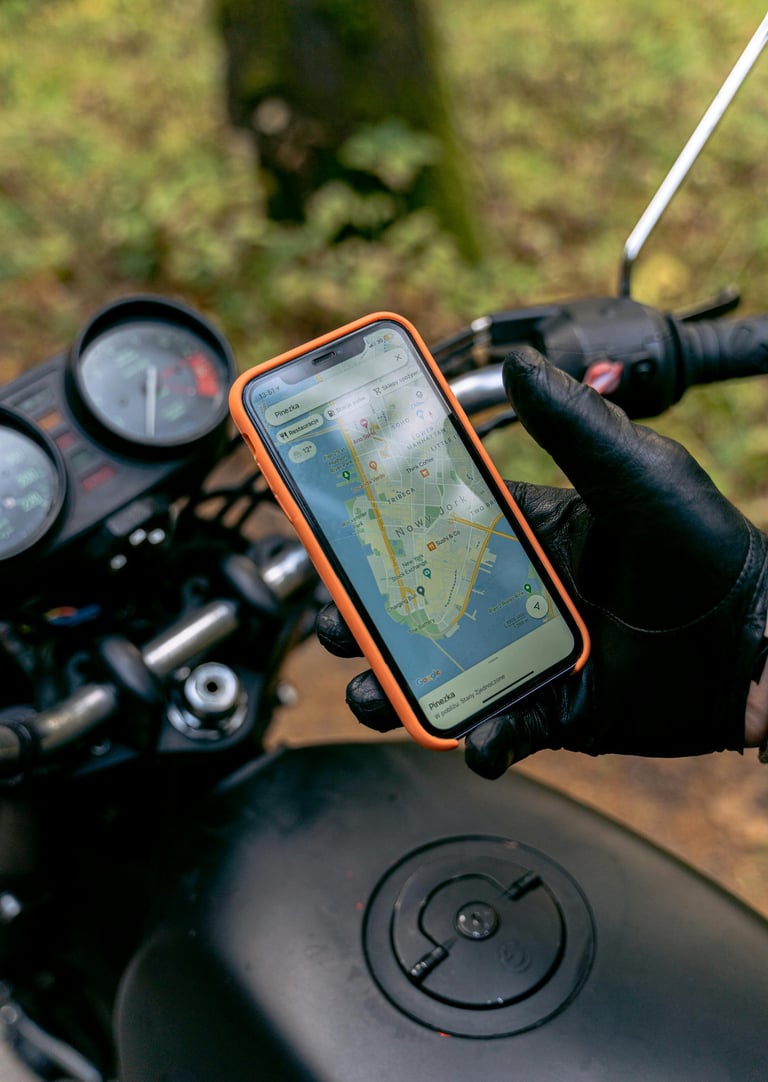 Adventure motorcyclist riding and checking GPS on phone to find his way to intensity Integration Coaching with GJ Silver.
