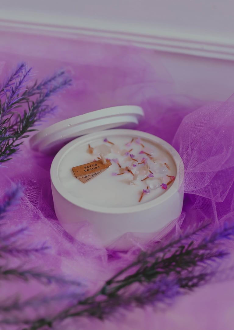 Vela de soja perfumada en un tarro de cerámica blanca decorado con lavanda sobre tul morado.