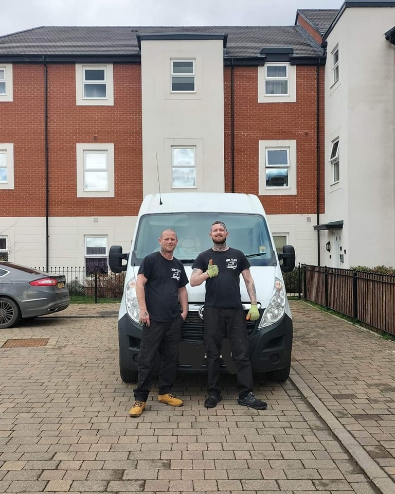 two men standing next to a van