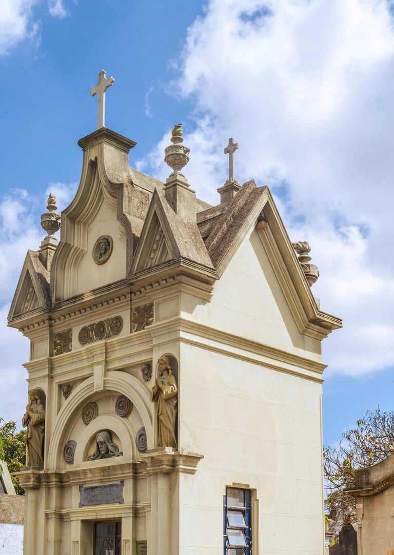 A imagem mostra uma igreja com uma torre de relógio no meio do cemitério araçá