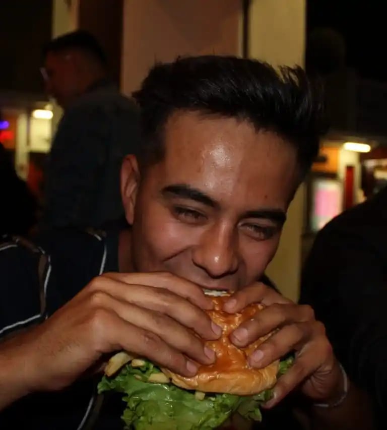 muchacho disfrutando de una jugosa carne de hamburguesa