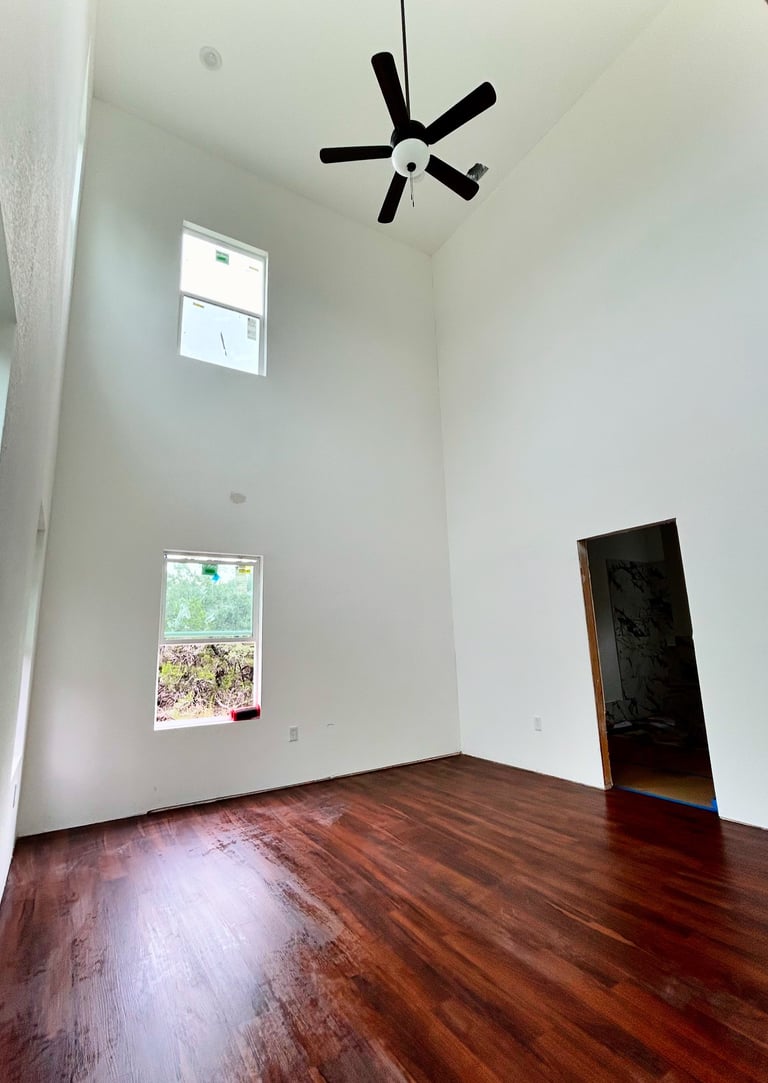 Primary bedroom with 20-foot ceilings and oversized windows in Texas custom home