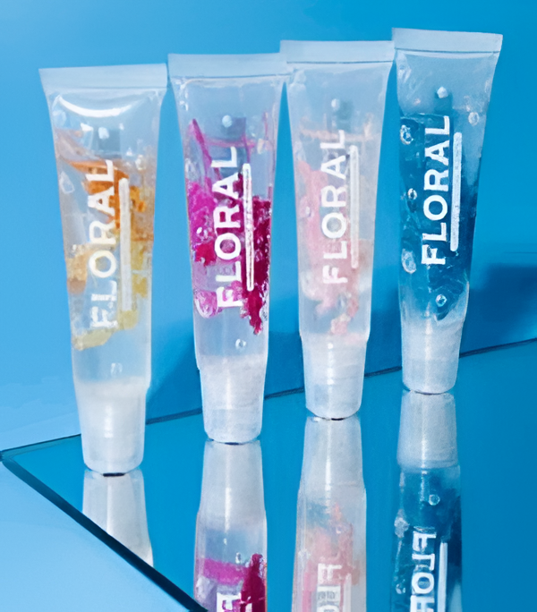 Cuatro tubos transparentes de brillo labial con motivos florales, pétalos de flores y burbujas sobre