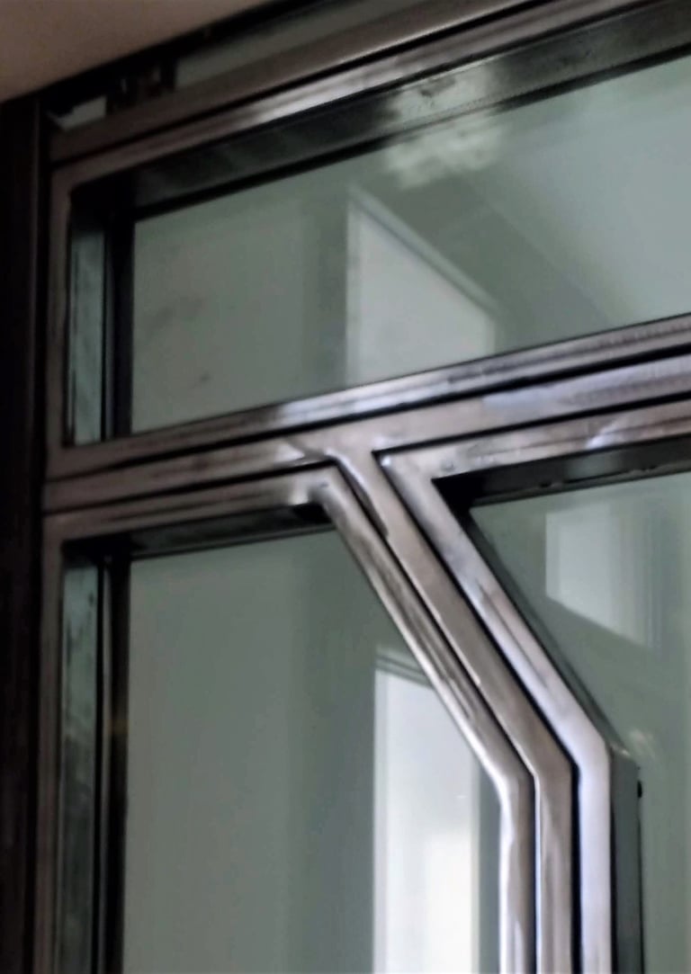 A glass door with custom-made raw steel elements