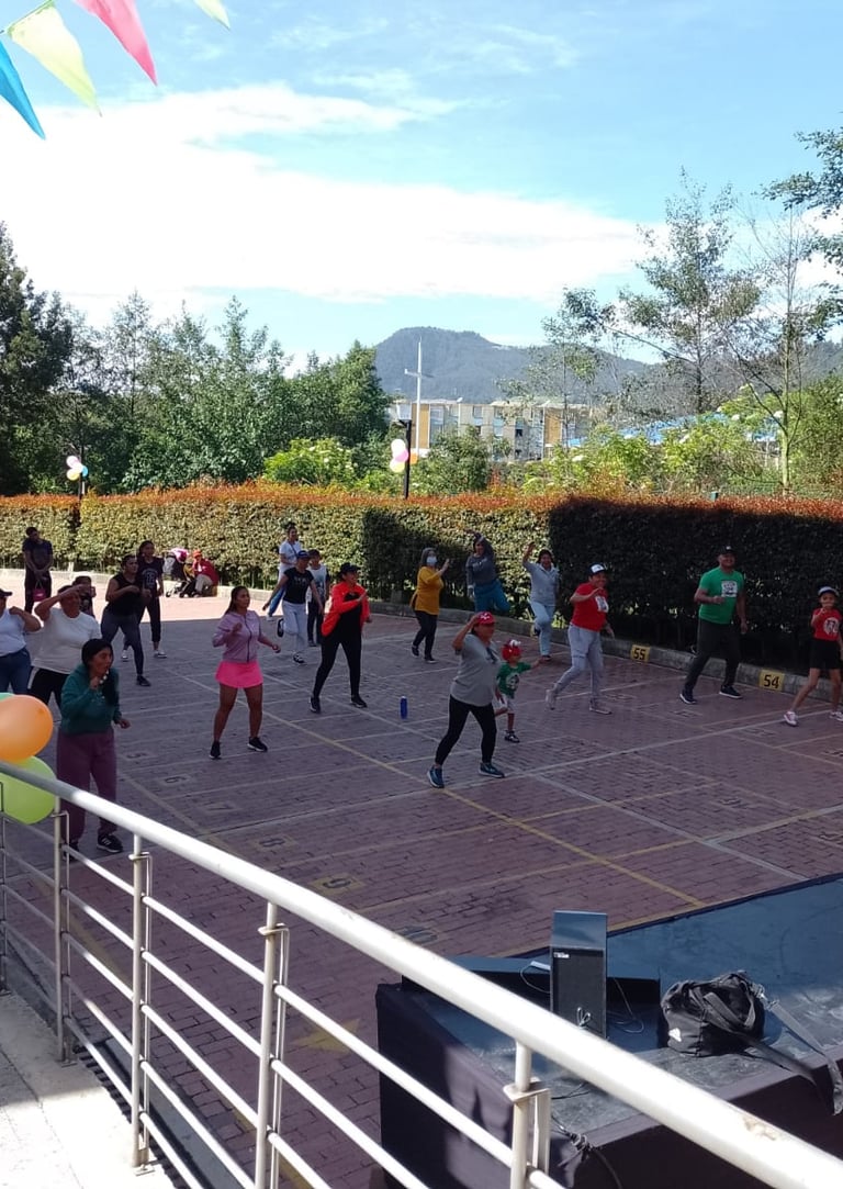 Grupo de personas disfrutando de una clase de Zumba en un ambiente animado y divertido.