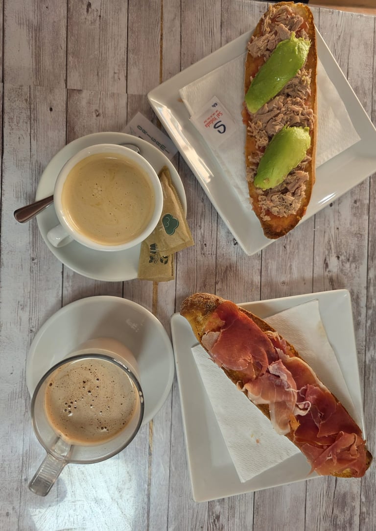 a table with a cup of coffee and a sandwich
