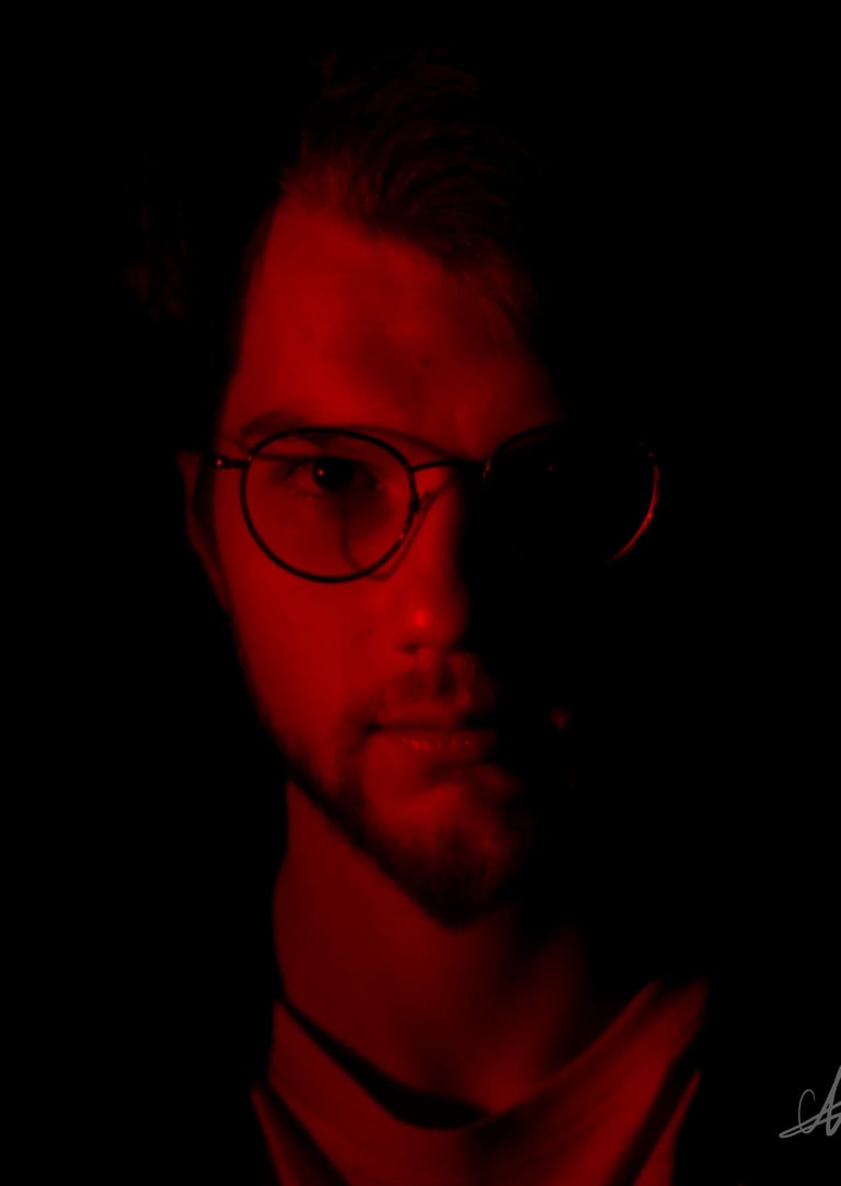 Thomas Rateau, le bassiste du groupe Rush On Mars éclairé de face par une Lumière rouge