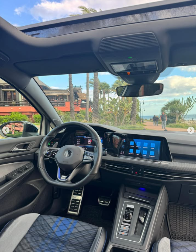 Interior view of a modern Volkswagen Golf with a digital cockpit, infotainment screen, and sunroof.