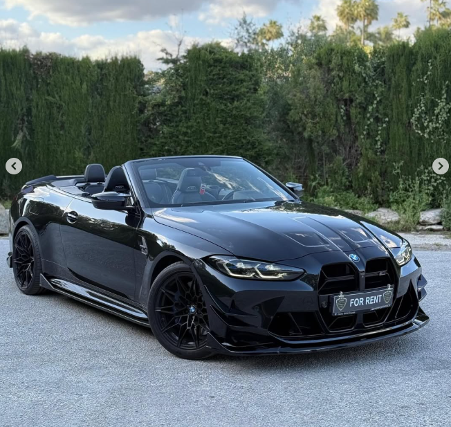 Sleek black BMW M4 convertible luxury sports car for rent parked outdoors.