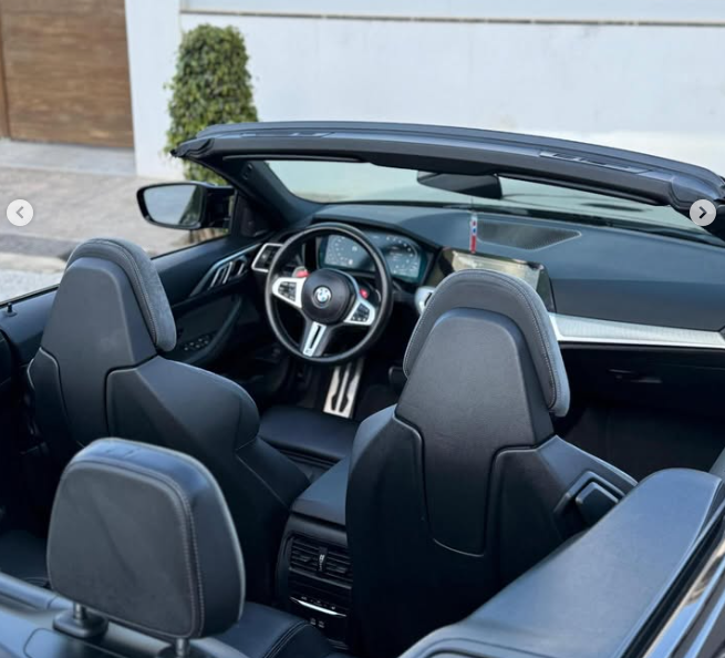 Interior view of a modern BMW convertible featuring black leather sports seats and a luxury dashboard.