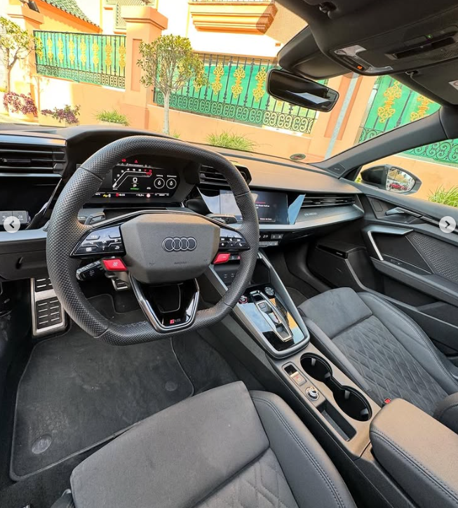 Luxury interior of an Audi RS model showing the leather steering wheel, digital dashboard, and sport seats.